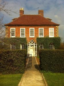 阿德敏斯特Whitchurch Farm Guesthouse的一座大型红砖房子,设有白色门
