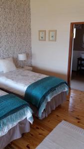 温特顿Shepherd Farm的一间卧室配有两张带绿色和白色床单的床
