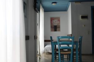 格利法达Glyfada Gorgona Apartments的一间配备有蓝色椅子和桌子的用餐室