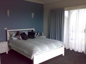 Ventnor天鹅湖旅馆的一间卧室配有一张蓝色墙壁的床和一扇窗户