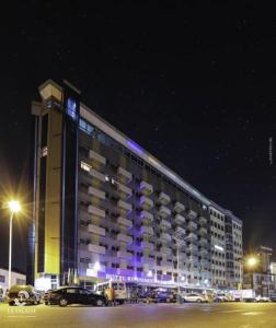杜阿拉拉法莱斯酒店的一座大建筑,晚上有紫色的灯光