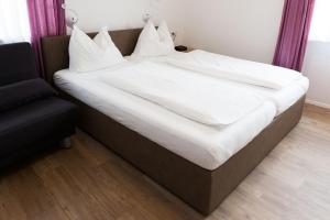 奥拉Gasthaus Abram的一张配有白色床单和枕头的大床