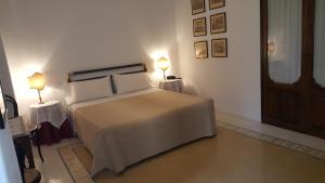 圣马里纳萨利纳圣塔马丽娜酒店的一间卧室配有一张带两张桌子和两盏灯的床。