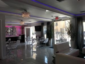 洛杉矶好莱坞贵宾酒店的客厅配有桌椅和粉红色的墙壁