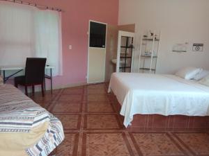 CosoleacaqueHospedaje Barrancas的一间卧室配有两张床、一张桌子和一张书桌
