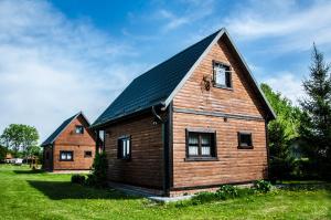 KątnoDomek nad Szelągiem的一座大型木房子,设有黑色屋顶