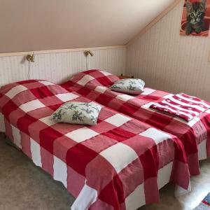 ÖdkarbyBorgdala Stugor的卧室内的两张床,配有红色和白色的毯子