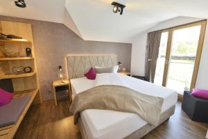弗劳埃瑙瓦尔德克里斯托尔膳食公寓的卧室配有一张带紫色枕头的大型白色床。
