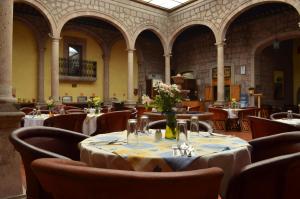 莫雷利亚卡勒里拉莫雷利亚豪生国际酒店的餐厅设有桌椅,并种有鲜花
