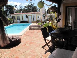米尔芳提斯城Casa dos Cactos的庭院设有游泳池、桌子和椅子。