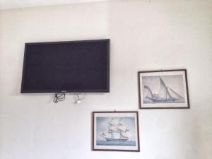切塞纳蒂科Bilocale Valverde的挂在墙上的平面电视,上面挂着图片
