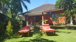 特贾库拉格德民宿的两把椅子坐在房子前面的草上