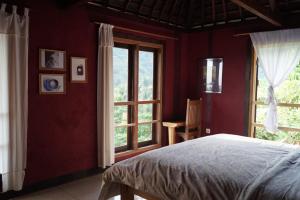 圣吉吉萨萨克乐邦度假屋的卧室设有红色的墙壁、一张床和窗户