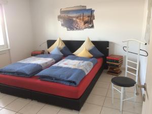 朗格奥Haus Nordland的一间卧室配有红色的床、蓝色枕头和梯子