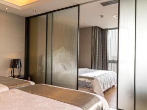 广州广州朋满公寓式酒店北京路捷登都会店-交易会免费巴士接送的酒店客房设有两张床和玻璃墙
