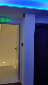 雅典雅典微风精品酒店的一间有蓝色灯光的房间和一扇有标志的门