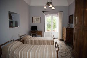 格拉维纳迪卡塔尼亚B&B Valle Allegra的一间卧室设有两张床和窗户。