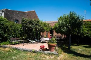 格拉维纳迪卡塔尼亚B&B Valle Allegra的花园内设有带桌椅的建筑
