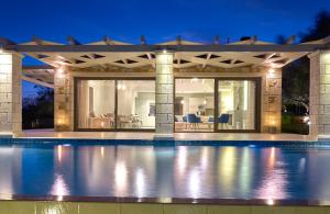 凯里翁Avra Luxury Villa & Spa的一座晚上设有游泳池的房子