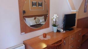 杰尔伊莎贝尔杰尔酒店的一间带镜子的卧室和一张带电视的书桌