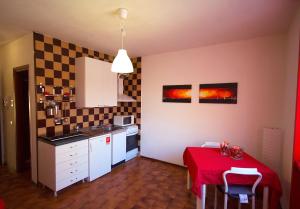 诺瓦拉[Ospedale] Casa DeMedicis的一个带桌子和红色桌布的小厨房