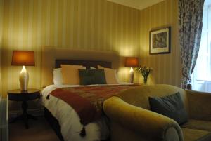 韦克斯福德吉利安城堡乡间别墅农场酒店的一间卧室配有一张大床和一张沙发