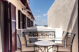 斯卡拉Agistri Hotel的阳台的天井配有桌椅