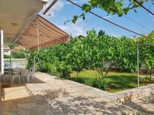 格基卡琳Apartmani Mlinar的庭院配有桌椅和树木