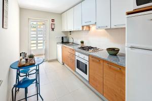 卡巴纳斯·德·塔维拉Mr. Stuart House的厨房配有白色橱柜和蓝色凳子