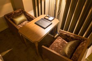 高松高松皇家花园酒店的一张桌子和椅子,上面有笔记本电脑和一本书