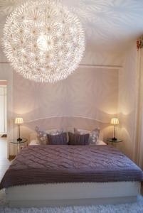 普雷罗浪漫风情公寓的一间卧室配有一张带大吊灯的床