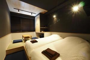 箱根MIRAHAKONE汤本站酒店的小房间设有两张床和窗户