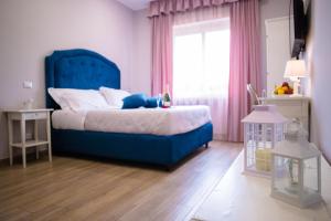 SelcettaRelais Villa Italia的一间卧室设有蓝色的床和窗户。