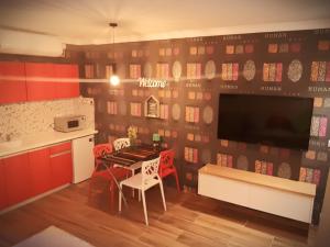 埃拉特城市公寓的一间带桌椅的厨房和一台电视