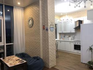 敖德萨Zhemchuzhnie apartments on Marselskaya的一间带砖墙的客厅和一间厨房