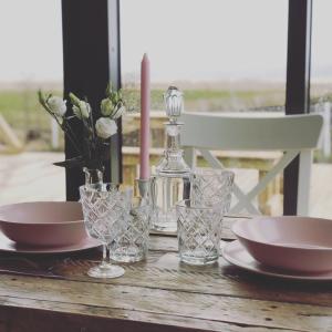 ÖlfusAkurgerði Guesthouse 8 - Country Life Style的一张桌子,上面有盘子和玻璃杯,还有一瓶