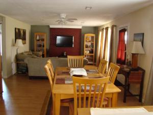 Lineville查普曼楼乡村民宿的用餐室以及带桌椅的起居室。