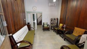 曼谷Home & Hashery Boutique House的一间设有椅子和墙上时钟的等候室