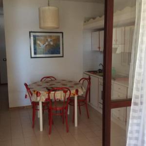 锡巴里Appartamento in residence Laghi di Sibari的厨房以及带桌椅的用餐室。