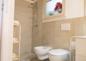 马蒂诺Family Deluxe Suite Salento的一间带卫生间和水槽的浴室以及一台电视。