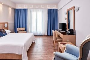 阿吉奥斯普罗科皮奥斯拉各斯马尔酒店的酒店客房,配有一张床、一张桌子和椅子