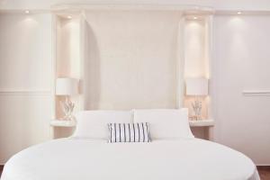 阿吉奥斯普罗科皮奥斯拉各斯马尔酒店的白色卧室设有白色床和2个窗户