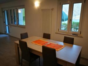 莱德罗Appartamento Chiara的一间带木桌和椅子的用餐室