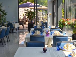 奥帕提亚Boutique Hotel Mali Raj的餐厅设有白色的桌子和蓝色的椅子