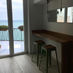 拉维罗Chez-Lu Ravello的带酒吧的厨房、阳台和2张凳子