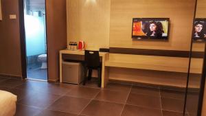 金宝金宝精品酒店（金宝中环）的酒店客房设有一张桌子和一台墙上的电视。