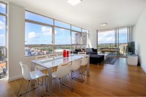 悉尼G1708S三卧室泽特蓝公寓的一间带桌椅和窗户的用餐室