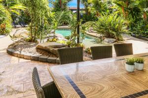 凯恩斯瀑布花园酒店的一个带桌椅的庭院和一个游泳池