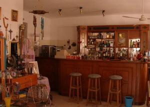 奥马斯帕纳吉亚斯Hotel Alexandros的一间酒吧,在房间里有两个凳子