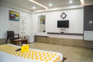 NarodaHotel Darshan SP Ring Road的一间设有床铺和墙上电视的客房